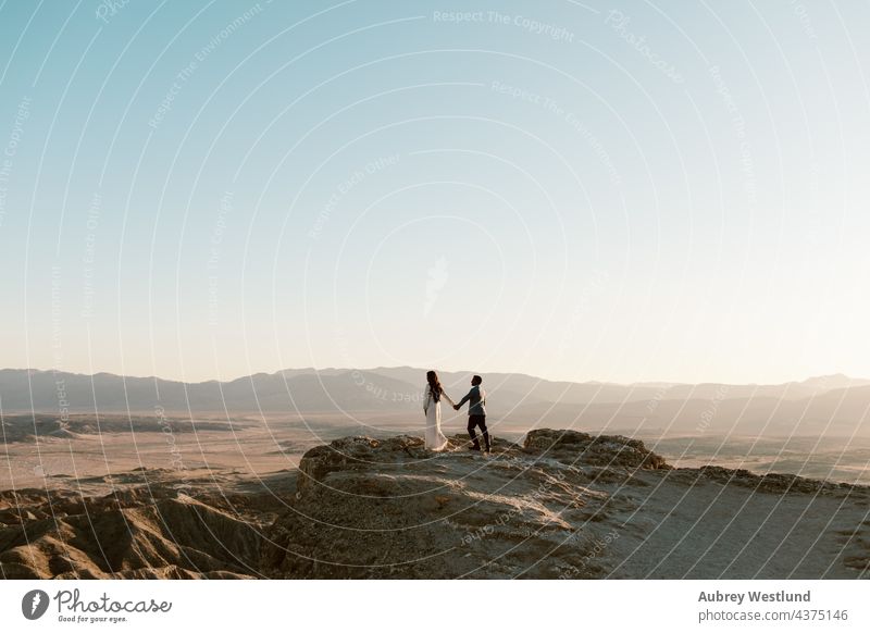 man and woman holding hands at a desert overlook anza borrego desert badlands cacti cactus couple dressed up erosion fonts point geology golden landscape