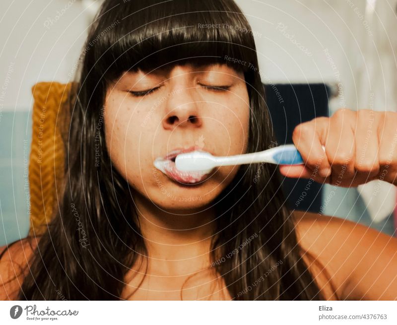 Tired woman in the morning with closed eyes brushing her teeth Brushing your teeth Woman tired Bathroom dental hygiene Dental care Toothbrush Closed eyes