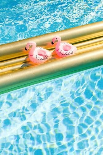 Two inflatable flamingos enjoy their lunch break on a golden air mattress in crystal clear water vacation Break Friends Couple Couples' holiday Summer vacation