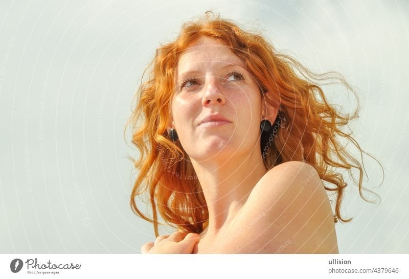 Beautiful sensual portrait of a thoughtful young redhead longing curly woman on vacation by the sea with copy space sovereign auburn beautiful hair pretty girl