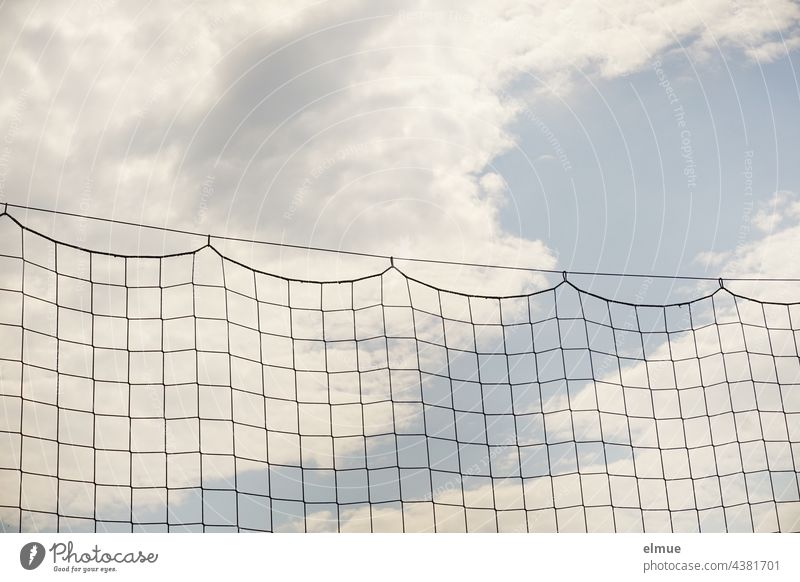 ball catching net on a steel cable in front of light blue sky with clouds / hang out / football / network Ball catching net safety net Net Safety Clouds Network