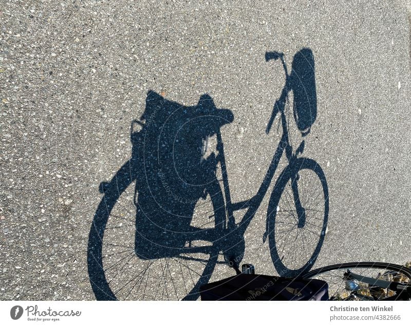 The shadow of a bicycle with saddlebags and handlebar basket Bicycle Shadow bicycle shadow panniers Handlebar basket Cycling Street Lanes & trails Asphalt