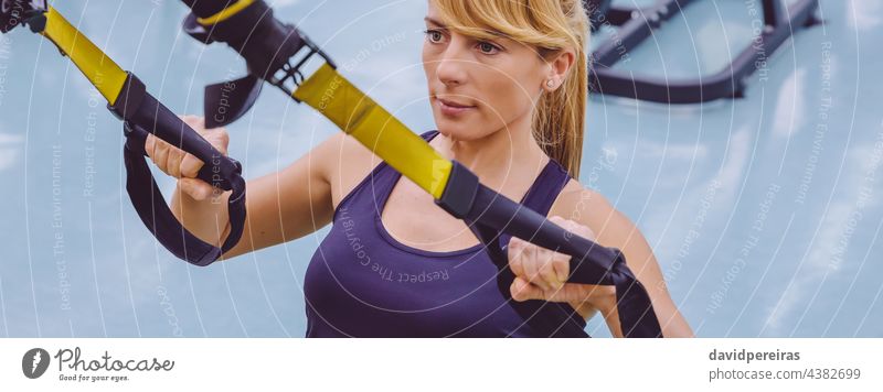 Woman doing suspension training with fitness straps panorama banner trx sportswoman gym copy space girl athlete caucasian female panoramic web header exercise