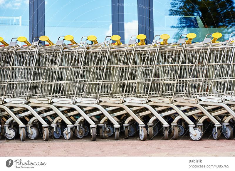 Row of empty shopping cart near a shop, close up supermarket basket retail store buy business background trolley grocery metal sale consumer purchase customer