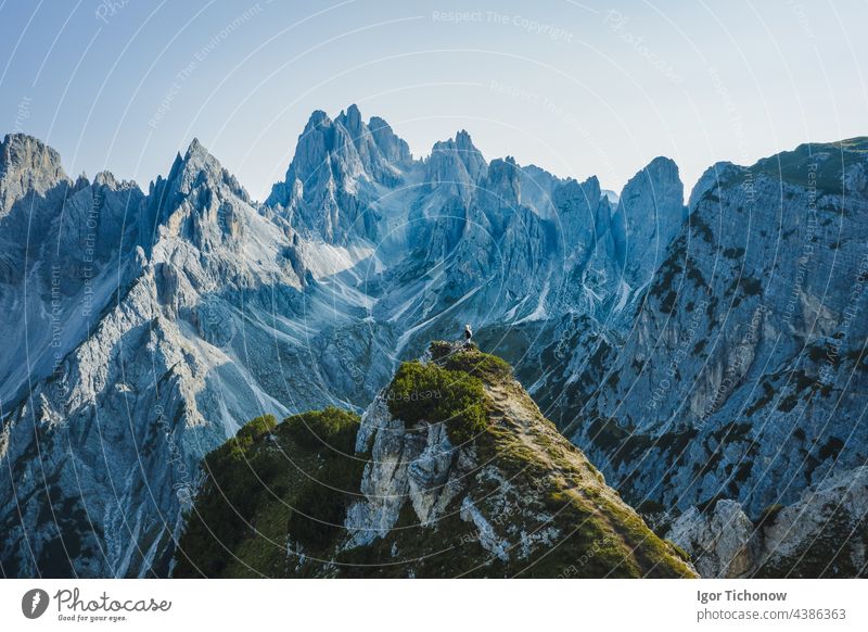 Aerial view of a woman hiker on mountain top enjoying Cadini di Misurina mountain peaks, Italian Alps, Dolomites, Italy, Europe dolomites aerial women cadini