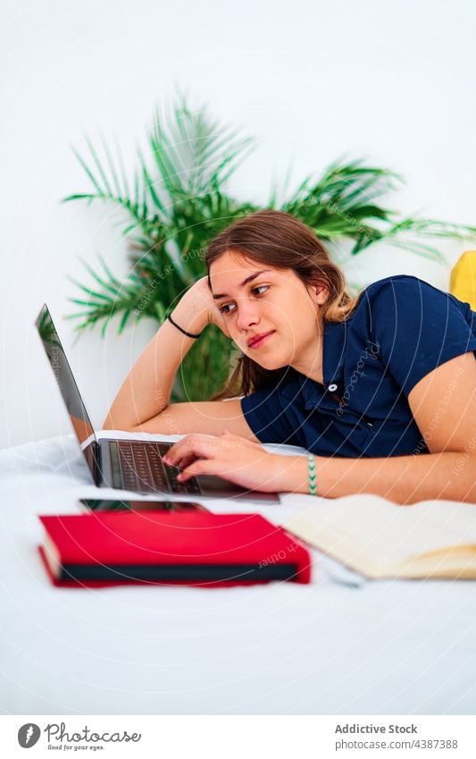 Happy woman working on laptop at home using remote digital online freelance bed female lying down young student communicate typing browsing gadget internet
