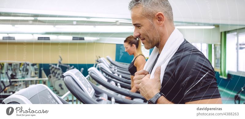 Portrait of man training over treadmill banner warming up copy space machine run running gym runner jogging cardio sport towel neck panoramic web panorama