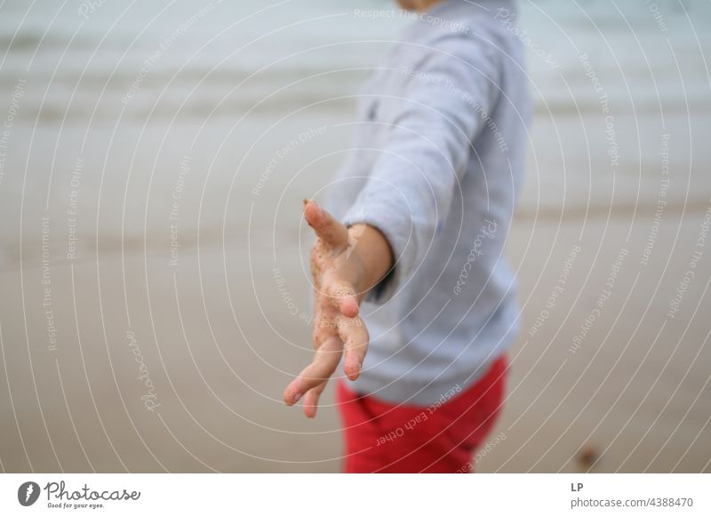 child alone on the beach pointing an arm towards the camera positive emotion Beach Risk Longing Individual Isolated Single Abstract Flow Children's game