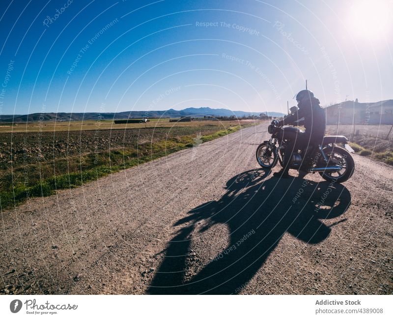 Unrecognizable motorcyclist riding bike on rural road ride countryside person drive motorbike vehicle transport travel adventure lifestyle freedom speed motion
