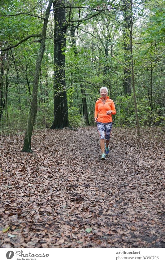 Senior woman in sportswear jogging through the forest Senior citizen Jogging Jogger Walking Forest Sports Sportswear active Fitness Healthy Athletic Lifestyle