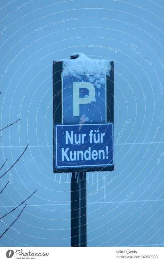Parking sign with P and Only for customers! in winter with snow and ice Parking lot For customers only Customer parking lot Ice Snow Winter Blue Exterior shot