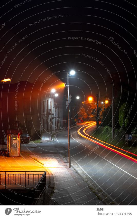 Vertical photograph of a country road of car lights in long exposure night speed transportation traffic motion fast trail urban blur drive vehicle evening