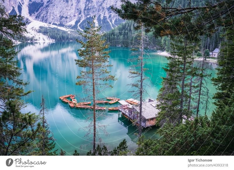Boathouse and wooden boats at Braies or Pragser Wildsee during sunset pink light. Dolomites, Italy braies lake pragser wildsee calm travel nature tourism italy