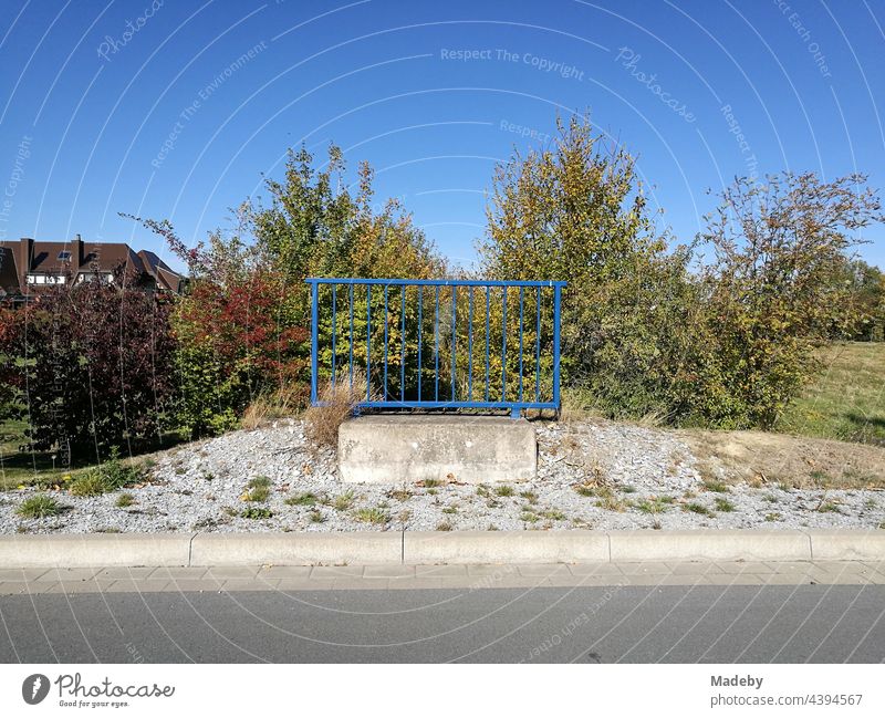 Lonely blue steel railing with concrete foundation alone in front of a blue sky in sunshine in Oelde near Warendorf in Westphalia in the Münsterland region of Germany