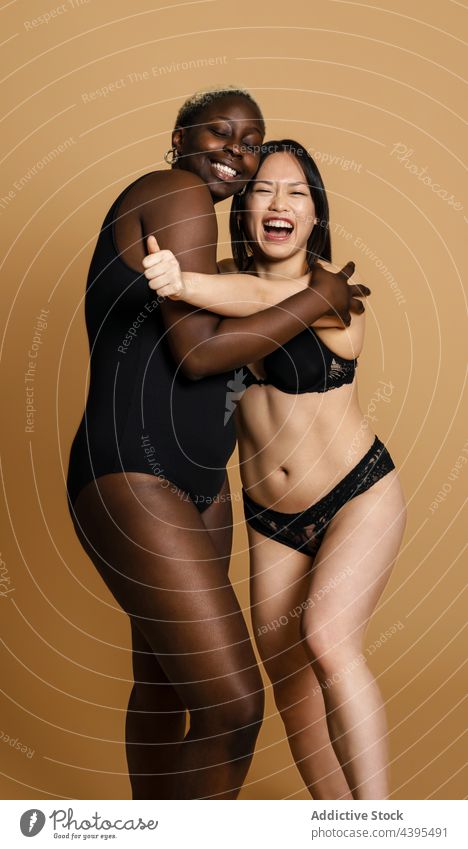 Cheerful Diverse Girlfriends Black Underwear Hugging Each Other Orange  Background Stock Photo by ©kegfire 673671822