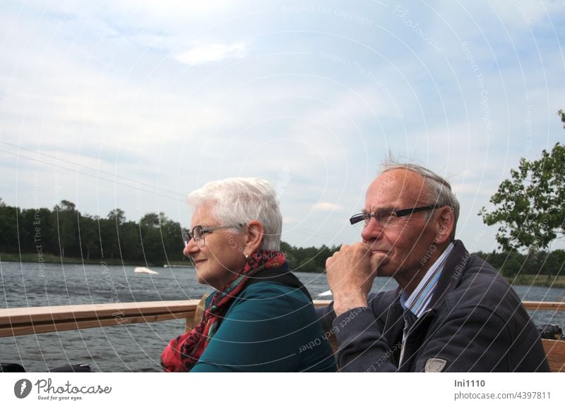 Senior couple as spectators in the water ski facility Lake Sport Water ski plant Visitor first row Beautiful weather Atcion free time fun senior citizens Couple