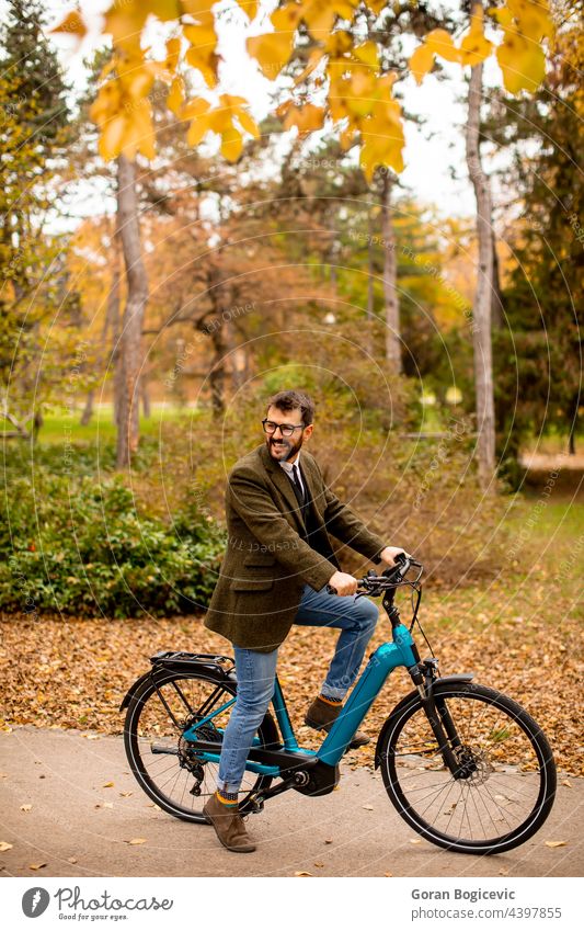 Young man with electric bicycle in the autumn park young nature lifestyle outdoor activity color ride summer bike day leisure people ebike travel sport city