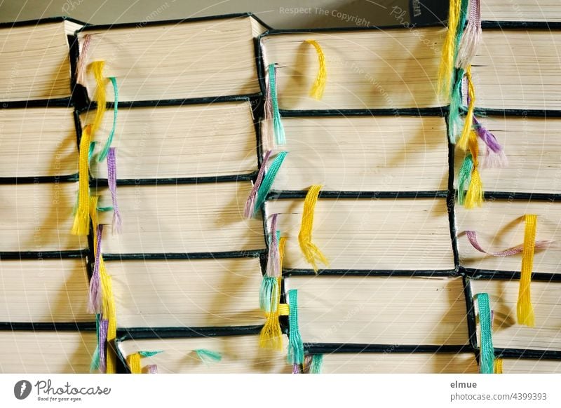 Side view of several stacks of the same books with colorful ribbons / reading / education Book Reading Stack Bible Reference Collection variegated Colour