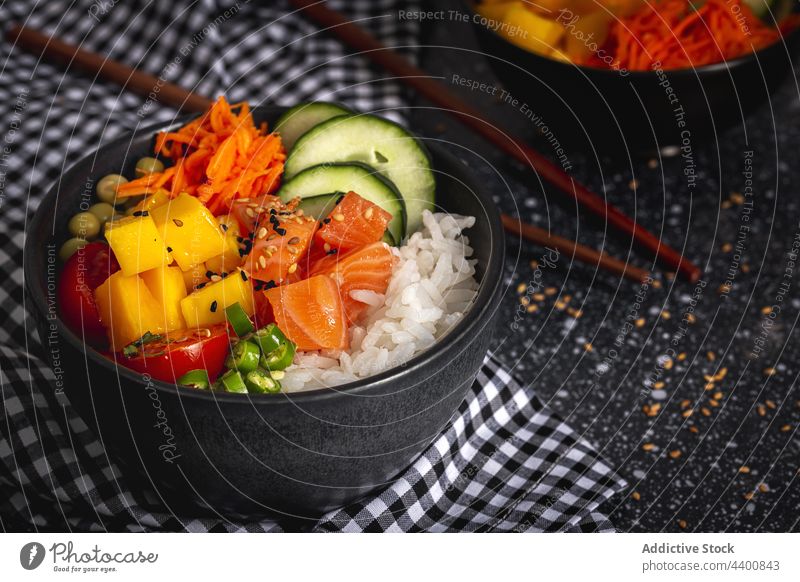 Bowl with tasty poke on table bowl fish dish tradition chopstick serve asian food vegetable salmon rice cuisine meal delicious appetizing fresh restaurant lunch