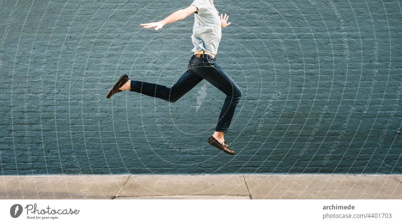 Man jumping against a wall man success fly concept happy happiness win anonymous unrecognizable street copy space joy excited fun reach excitement action young