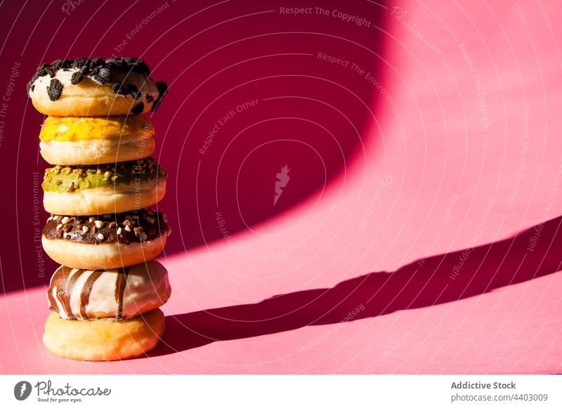 Stack of donuts on pink background doughnut calorie deliciously brown sprinkle eat fried pastry bakery 1 breakfast strawberry stacked baked cream unhealthy