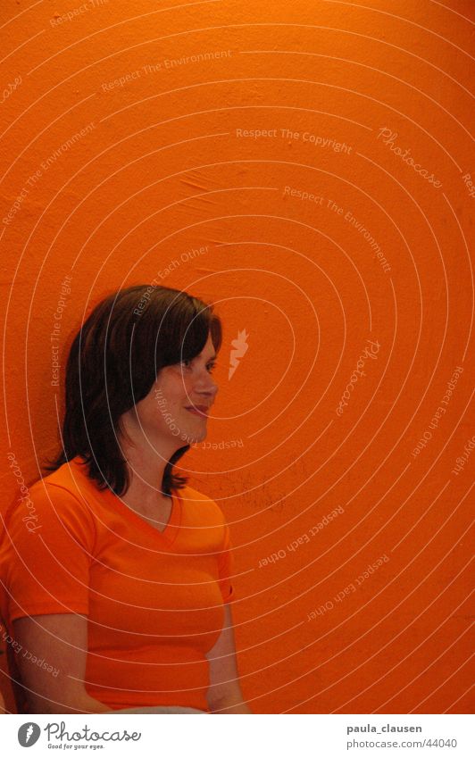 Ute in orange Brunette Tone-on-tone Portrait photograph Audience Woman Orange orange wall Orange T-Shirt Human being Looking Loneliness Interest