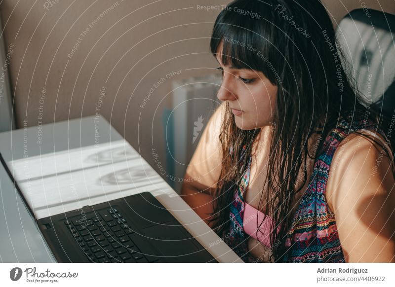 Lovely latina businesswoman using facial recognition technology working with a laptop. student computer modern table office meeting online caucasian reader