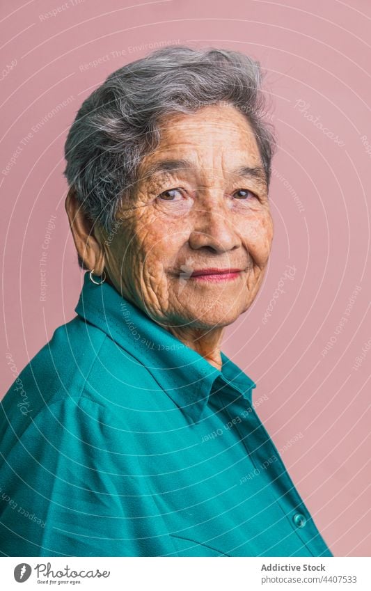 Senior woman with gray hair looking at camera senior appearance elderly brown eyes complexion aged portrait studio female style personality individuality calm