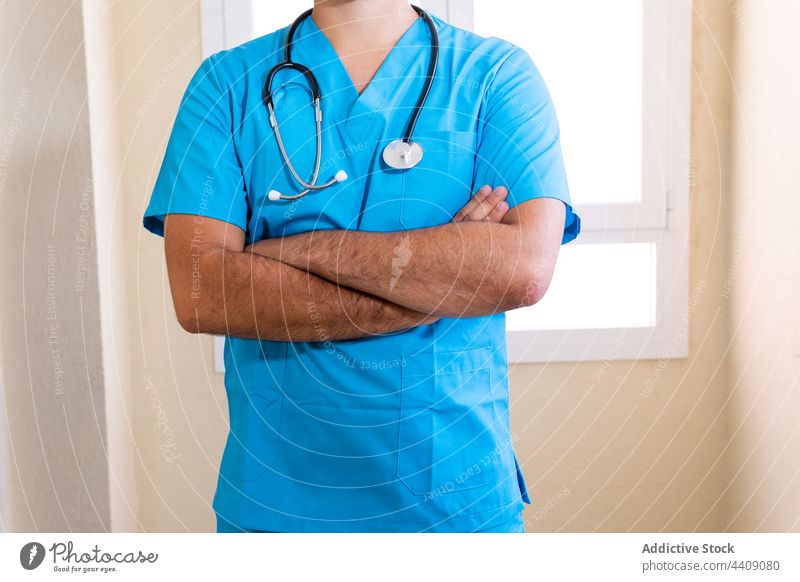 Crop doctor with stethoscope in hospital blue uniform medic man professional medical specialist male surgeon health care healthy staff work job practitioner
