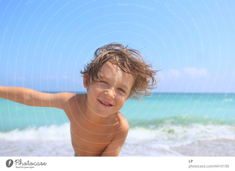 face of a beautiful child smiling at the camera on the seashore positive emotion smile Ocean Beach Individual Isolated Single Abstract Movement Flow