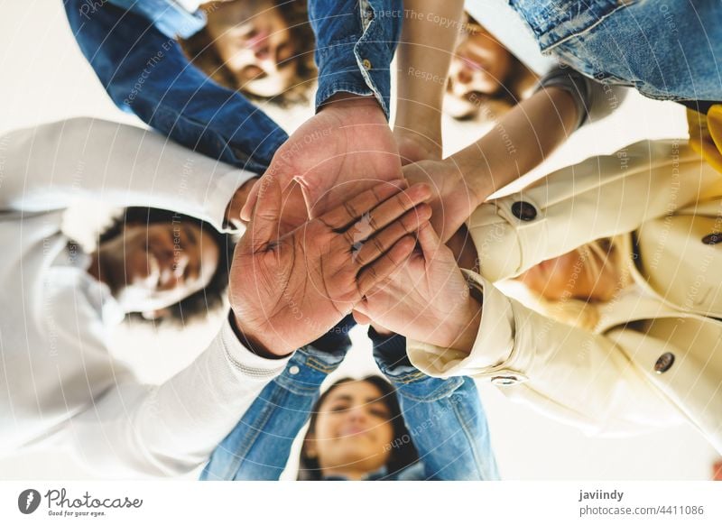 Hands of a multi-ethnic group of friends joined together as a sign of support and teamwork. hand people woman friendship students young partnership youth