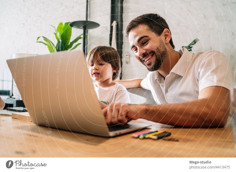 A father helping his son with online school at home. monoparental laptop homework student learning lifestyle quarantine family children people lock down indoor