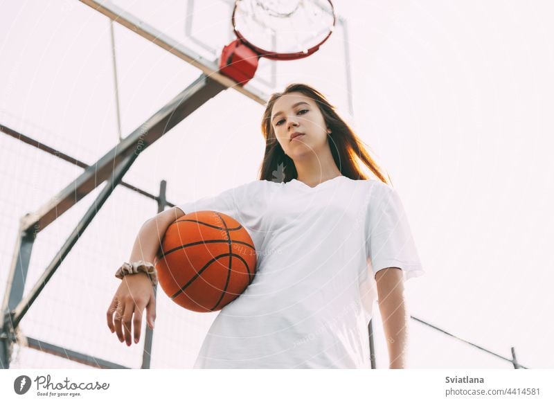Portrait of young female basketball player. Beautiful teen girl playing basketball. in sportswear playing basketball teenager active woman caucasian portrait