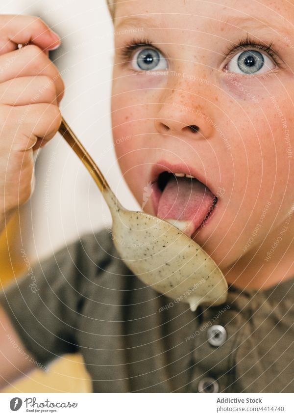 Child with spoon eating cream soup child lick lunch boy meal food home kid dish tasty kitchen cute yummy cuisine nutrition healthy appetite adorable delicious