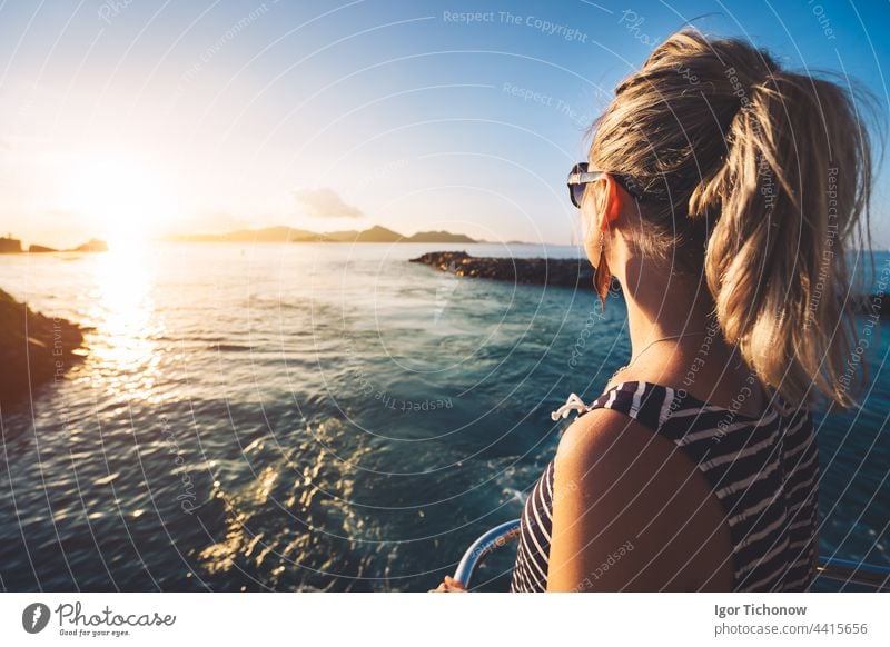 Young adult women enjoying sunset over ocean from ferry boat, Seychelles island, La Digue seychelles golden silhouette girl digue young travel summer vacation