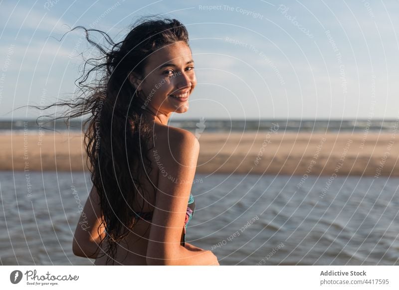 Woman in swimsuit on seashore in summer woman beach vacation enjoy holiday cheerful female swimwear summertime sunlight sunny coast wet water positive idyllic