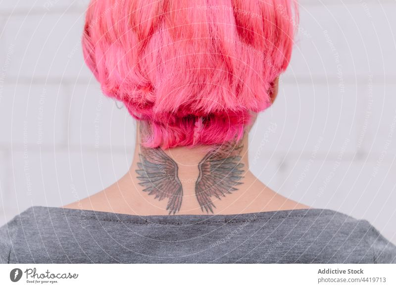 Crop woman with pink hair and tattoo trendy style hairstyle creative urban contemporary unusual neck female wall individuality personality fashion cool modern