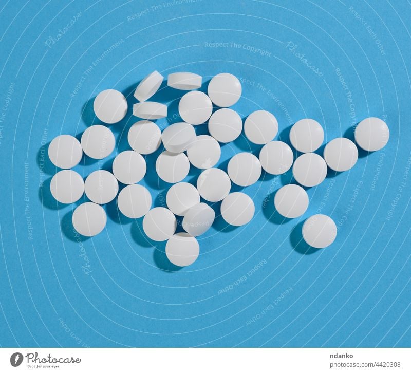 White round pill for healthcare. Medical treatment, blue background flat aspirin chemical chemistry circle closeup disease dose drug headache healthy heap