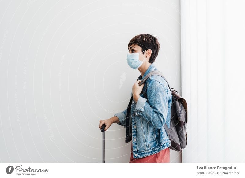 caucasian woman at train station waiting to catch train wearing face mask. Travel concept during pandemic corona virus protection phone disposable portrait