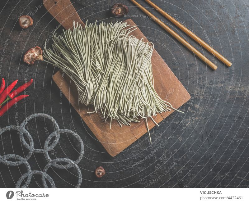 raw-homemade-asian-noodles-on-dark-kitchen-table-with-chopsticks-top