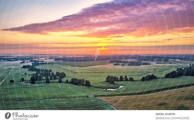 Dramatic summer sunrise. Panorama misty landscape. Foggy Morning on river aerial view. Green fields and meadows nature sky sunlight sunset outdoor clouds