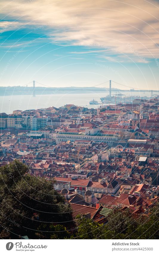 Houses near river and bridge house shore city morning roof historic district architecture lisbon portugal 25 de abril bridge tagus river building water