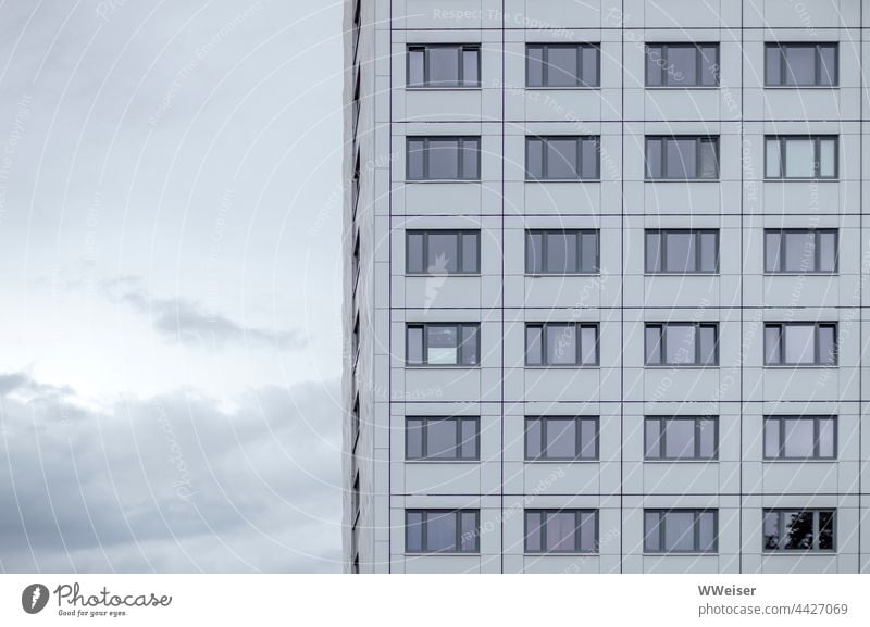 An apartment building with anonymous windows in front of a slightly cloudy evening sky Apartment Building Residential accommodation Student accommodation