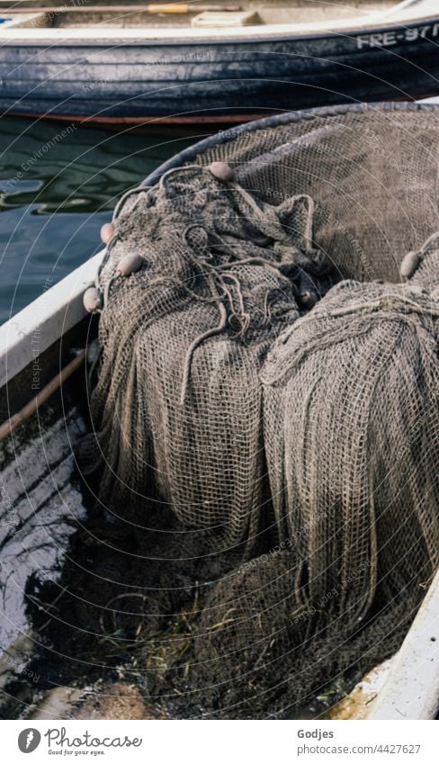 an old fishing net lies in a small fishing boat - a Royalty Free Stock  Photo from Photocase