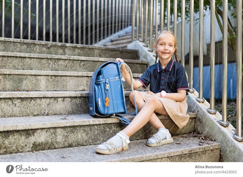 Schoolgirl back to school after summer vacations. Child in uniform with backpack early morning outdoor. education public school schoolchild student pupil
