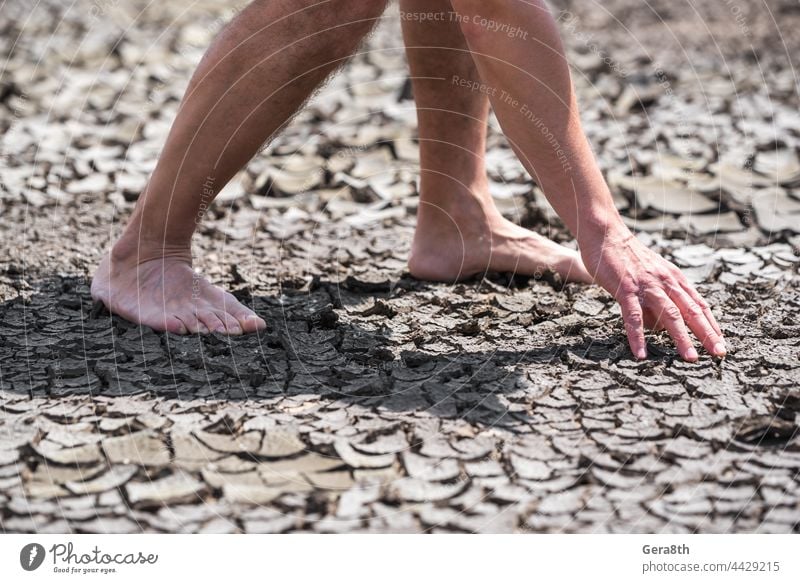 bare feet of a person on dry soil without plants close up arid background bad ecology barefoot climate cracks crisis desert disaster drought earth environment