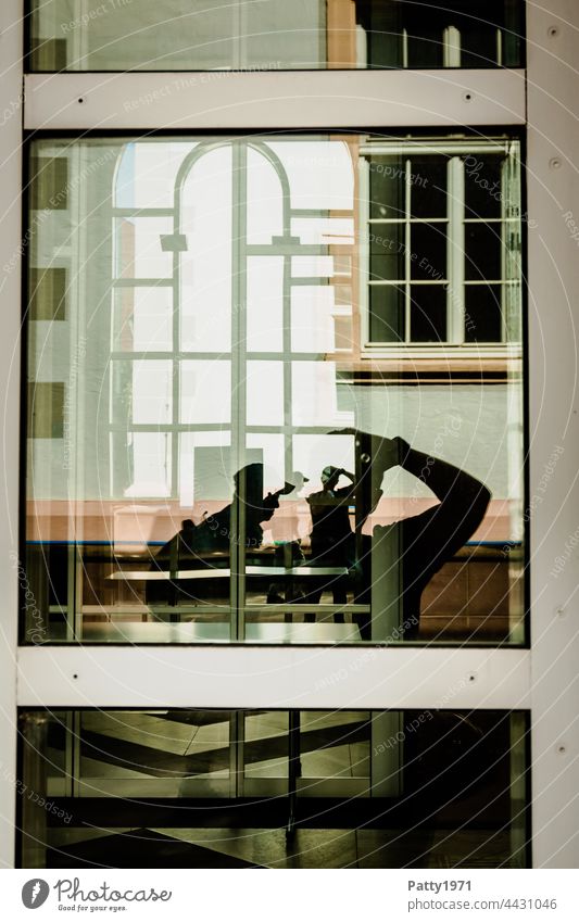 Human silhouettes in front of a geometric facade reflected in a glass pane | Order in chaos Silhouette Human being Window Glass reflection Reflection