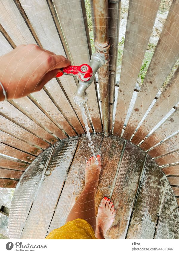 A woman washes the sand off her feet at a beach shower Beach shower Wash vacation Shower Woman Shower (Installation) Water out beach holiday Drops of water Legs