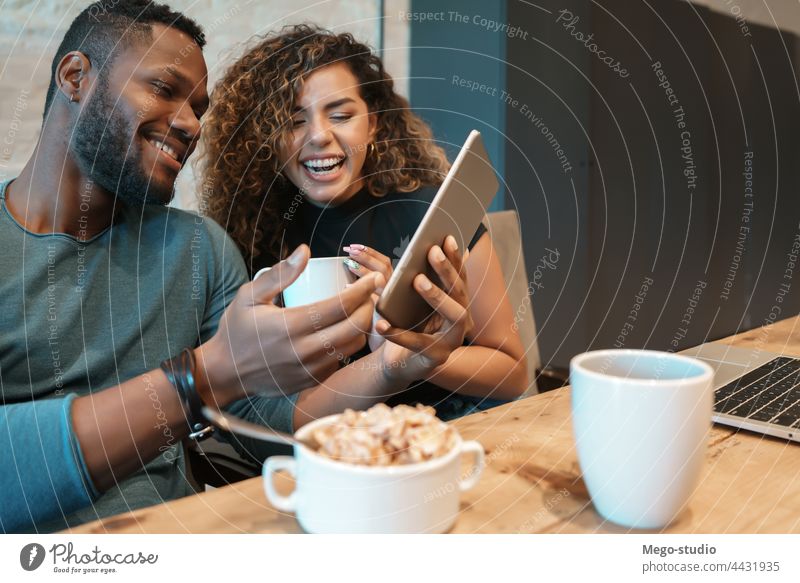 Couple using a digital tablet while having breakfast. young couple together indoors lifestyle quarantine food kitchen technology enjoying sitting woman home two