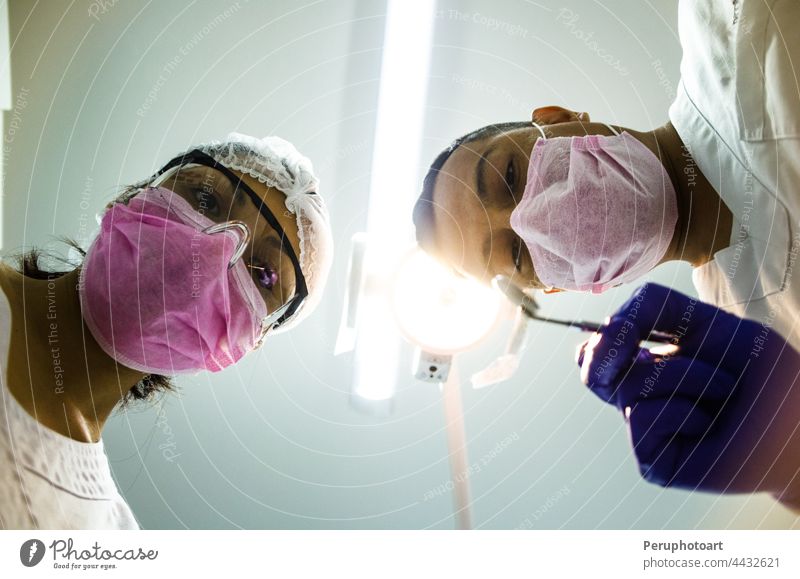 Portrait of two surgeons at work, operating in uniform, looking at the camera. covid-19 coronavirus nurses hospital doctor people group health operation